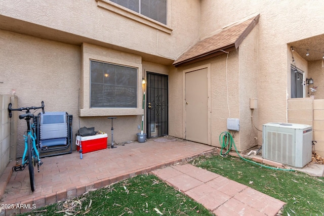 entrance to property featuring a patio and central AC