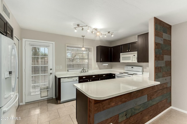 kitchen featuring pendant lighting, white appliances, sink, dark brown cabinets, and kitchen peninsula