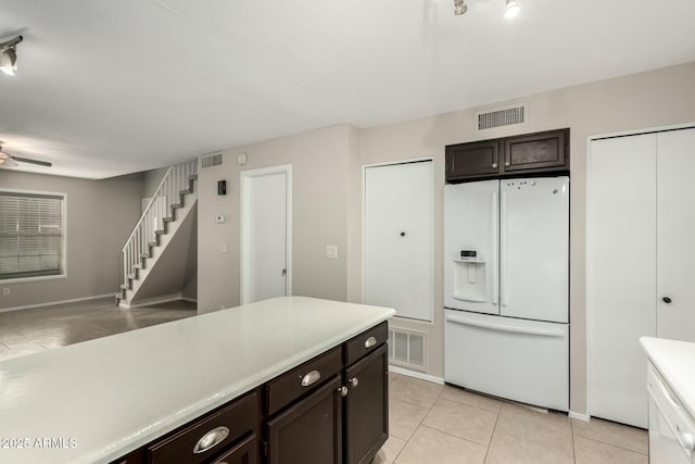 kitchen with dark brown cabinetry, ceiling fan, light tile patterned floors, and white refrigerator with ice dispenser