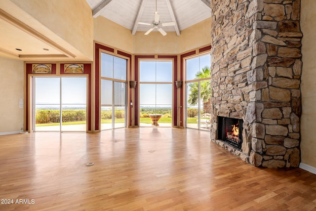 unfurnished living room with high vaulted ceiling, light hardwood / wood-style floors, and a healthy amount of sunlight