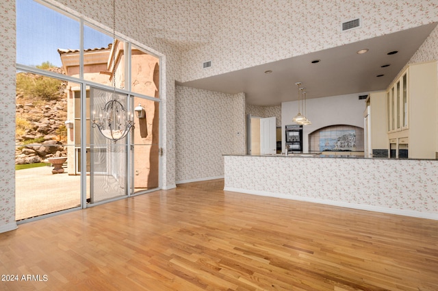 interior space with a notable chandelier, sink, and light wood-type flooring