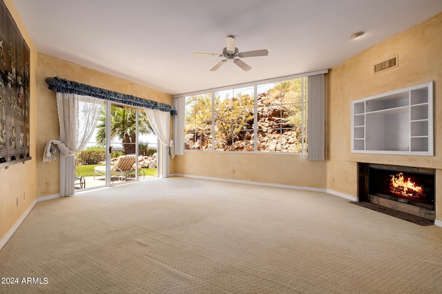 interior space featuring a wall of windows, ceiling fan, and carpet flooring