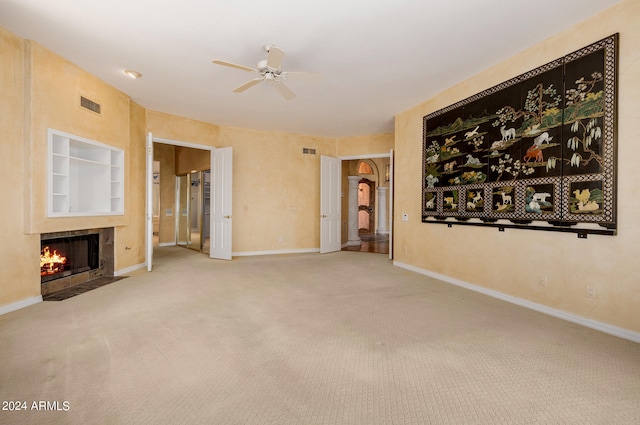 unfurnished living room with carpet flooring, ceiling fan, and a fireplace