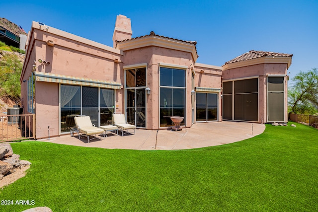 rear view of house featuring a yard, cooling unit, and a patio