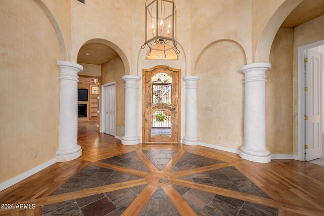 entrance foyer with a high ceiling, decorative columns, and hardwood / wood-style flooring