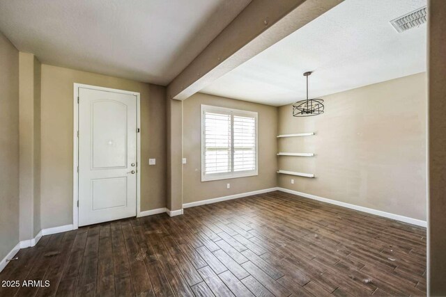 interior space featuring an inviting chandelier, dark wood finished floors, visible vents, and baseboards