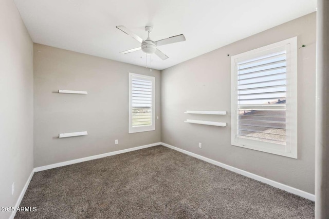 carpeted spare room with ceiling fan and baseboards