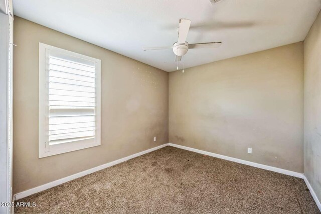 carpeted empty room with ceiling fan and baseboards