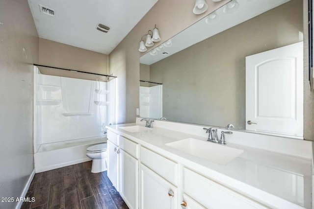 full bathroom featuring double vanity, a sink, toilet, and wood finished floors