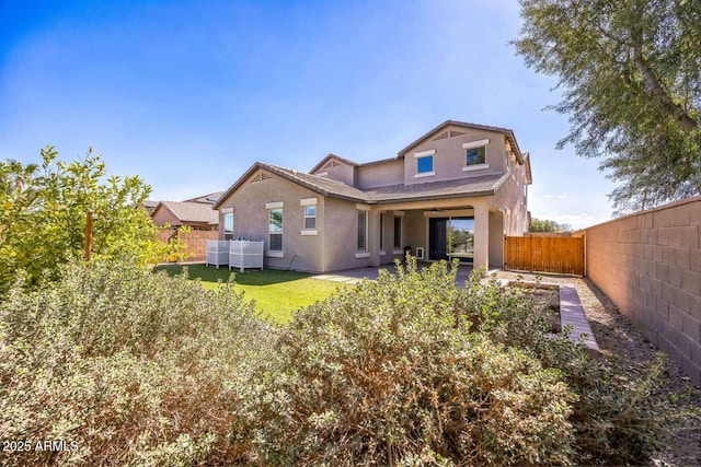 rear view of house featuring a lawn, a patio, a fenced backyard, central air condition unit, and stucco siding