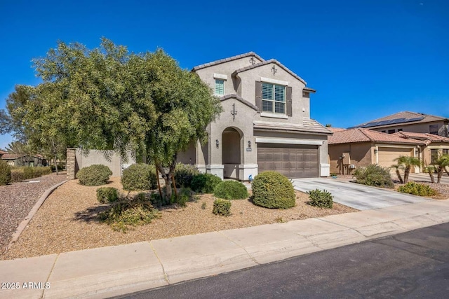 view of front facade with an attached garage, a tile roof, concrete driveway, and stucco siding