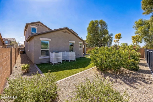 view of side of property with a yard, a fenced backyard, and stucco siding