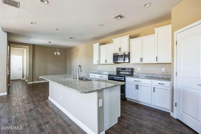 kitchen with visible vents, a center island with sink, appliances with stainless steel finishes, and a sink