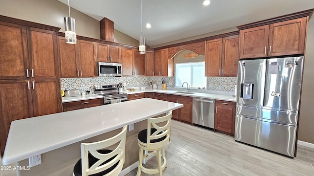 kitchen with decorative backsplash, lofted ceiling, appliances with stainless steel finishes, and a sink