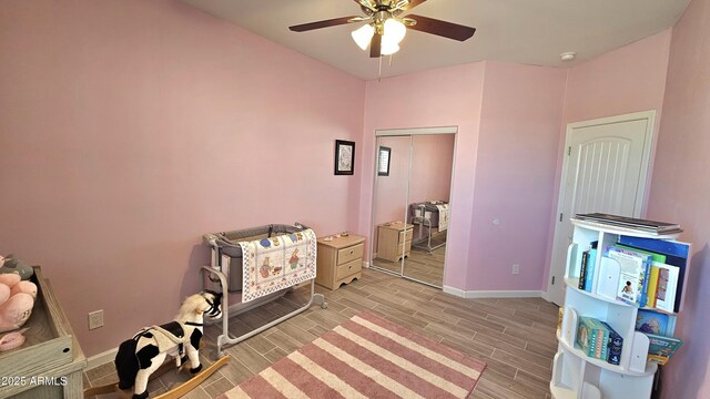 rec room with baseboards, ceiling fan, and wood tiled floor