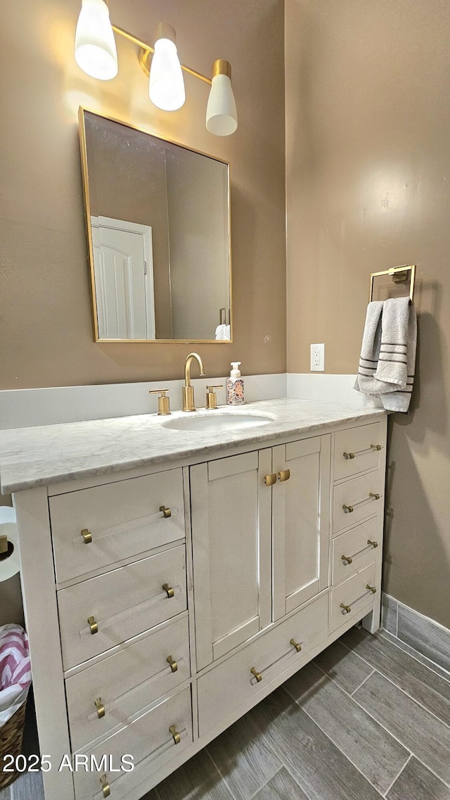 bathroom featuring vanity, baseboards, and wood tiled floor