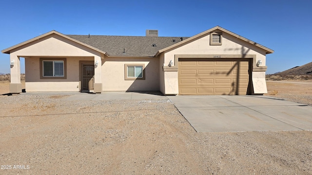 ranch-style home featuring roof with shingles, an attached garage, driveway, and stucco siding