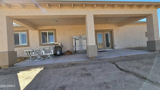 exterior space with french doors, a patio, and stucco siding