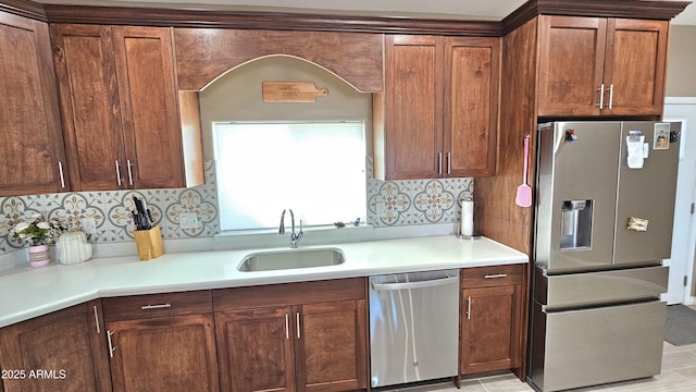 kitchen featuring a sink, decorative backsplash, appliances with stainless steel finishes, and light countertops