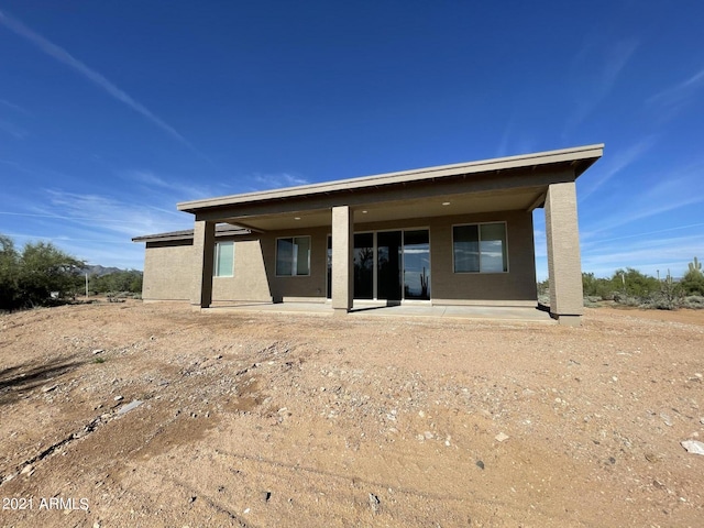 back of house featuring stucco siding and a patio