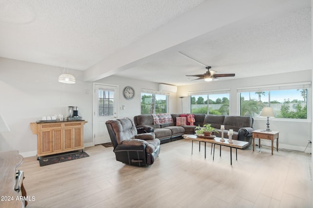 living room with ceiling fan, a textured ceiling, and light hardwood / wood-style flooring