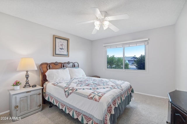 carpeted bedroom with ceiling fan and a textured ceiling