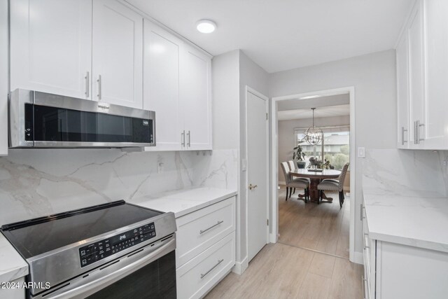 kitchen featuring range, tasteful backsplash, light hardwood / wood-style flooring, and light stone countertops