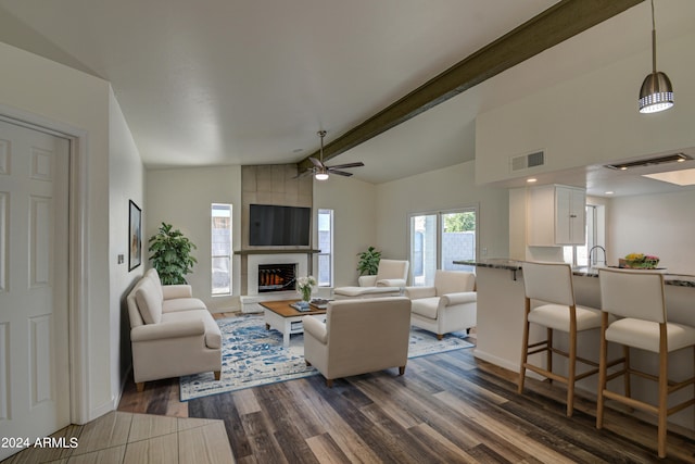 living room featuring a fireplace, vaulted ceiling with beams, sink, dark hardwood / wood-style flooring, and ceiling fan