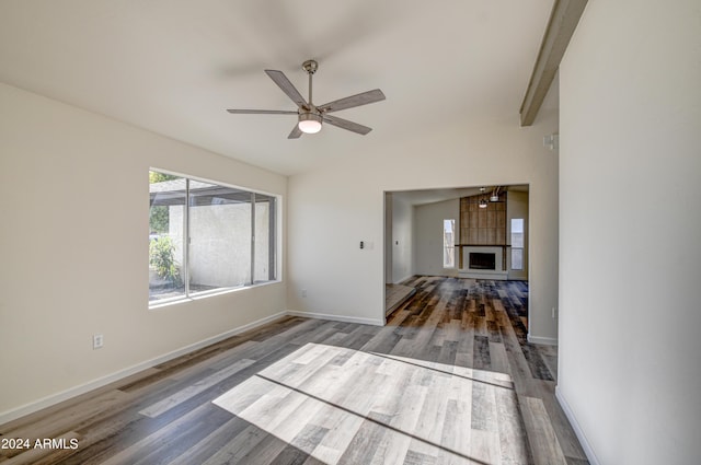 unfurnished living room with lofted ceiling with beams, dark hardwood / wood-style floors, and ceiling fan