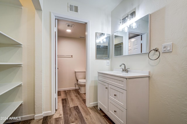 bathroom with vanity, hardwood / wood-style flooring, and toilet