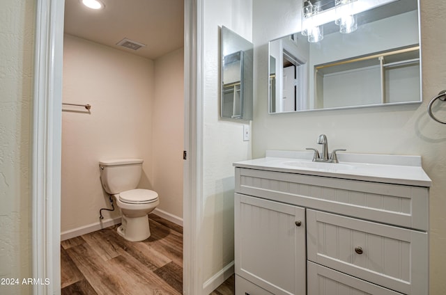 bathroom with hardwood / wood-style flooring, vanity, and toilet