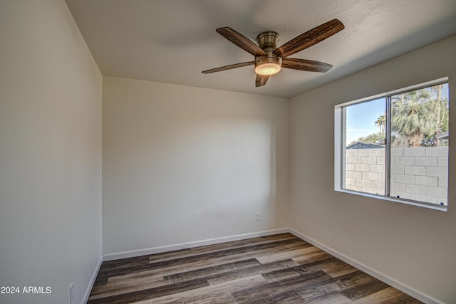 unfurnished room with dark hardwood / wood-style flooring and ceiling fan