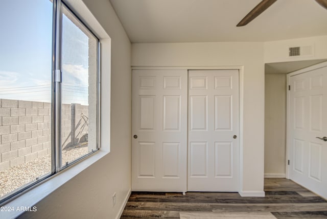 unfurnished bedroom featuring ceiling fan, dark hardwood / wood-style flooring, and a closet