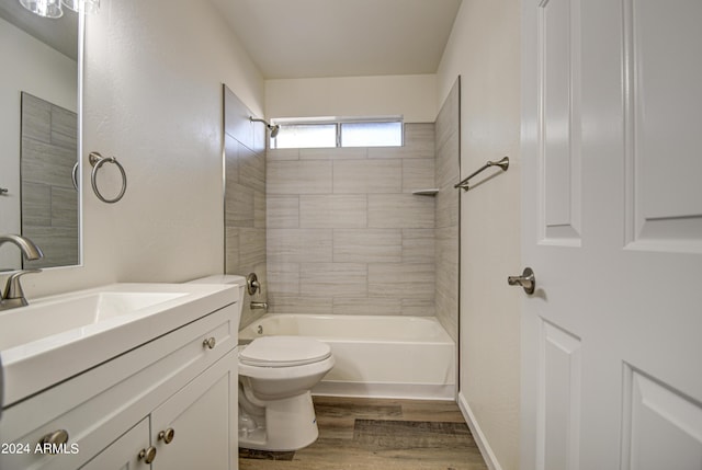 full bathroom featuring tiled shower / bath, vanity, toilet, and hardwood / wood-style floors