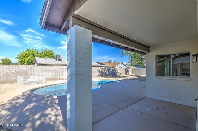 view of swimming pool with sink and a patio