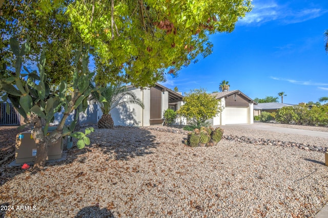 view of property hidden behind natural elements featuring a garage