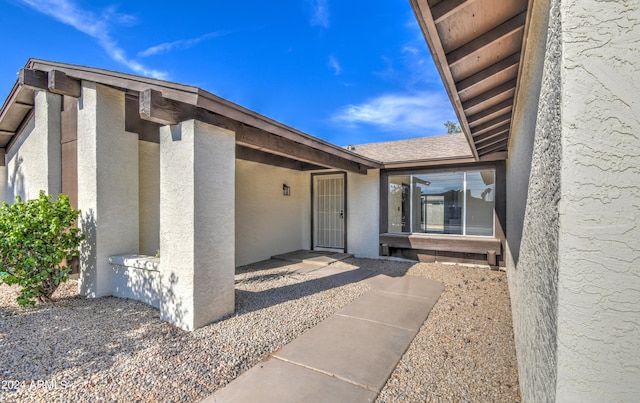 view of exterior entry with a patio area