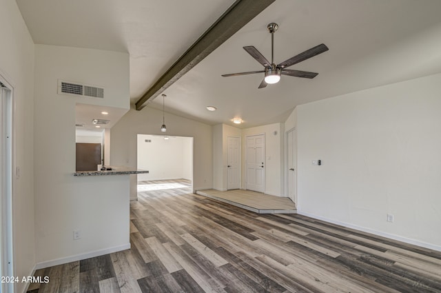 unfurnished living room featuring ceiling fan, wood-type flooring, and lofted ceiling with beams