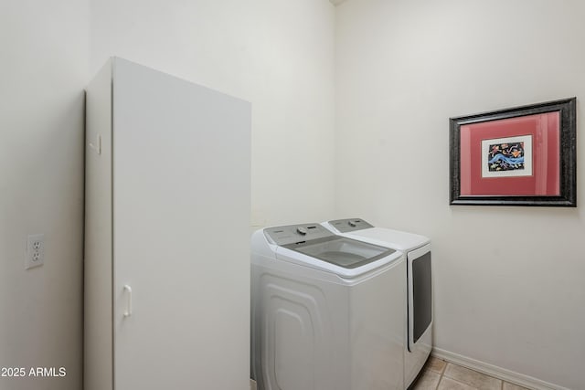 clothes washing area featuring light tile patterned floors and washer and clothes dryer