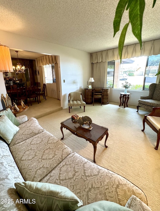 living room featuring a textured ceiling, an inviting chandelier, and carpet floors