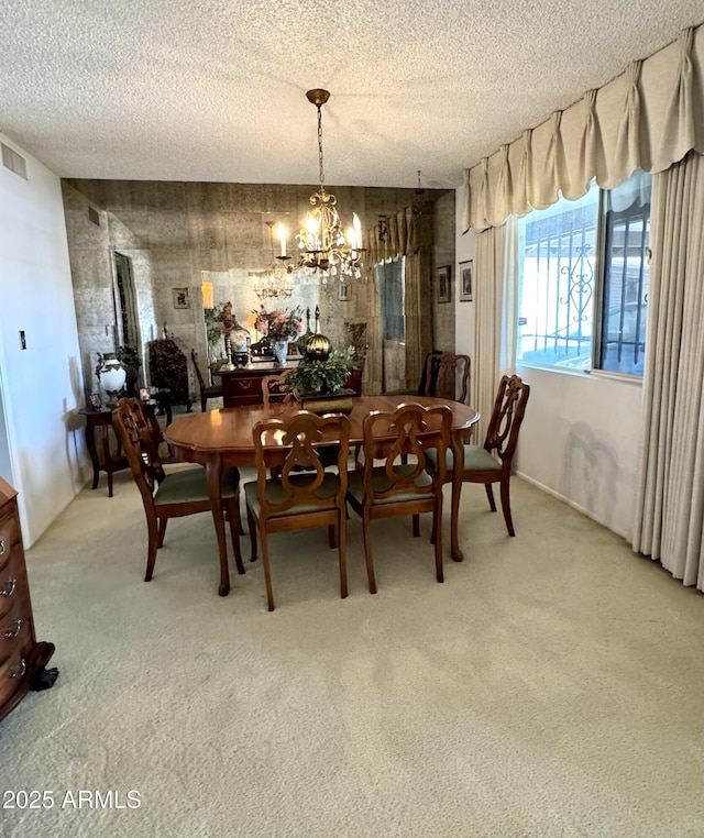 dining space featuring light colored carpet, a textured ceiling, an inviting chandelier, and visible vents