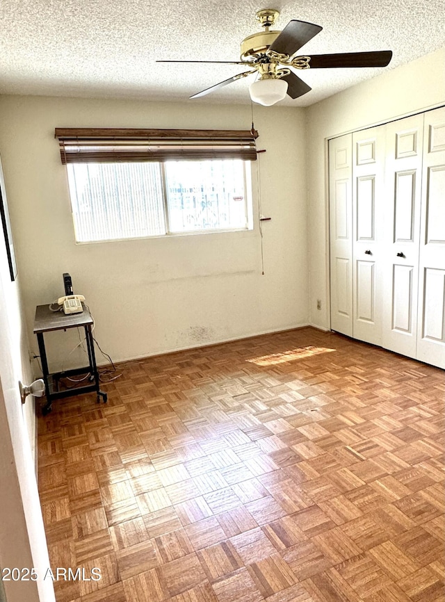 unfurnished bedroom featuring a closet, a ceiling fan, and a textured ceiling