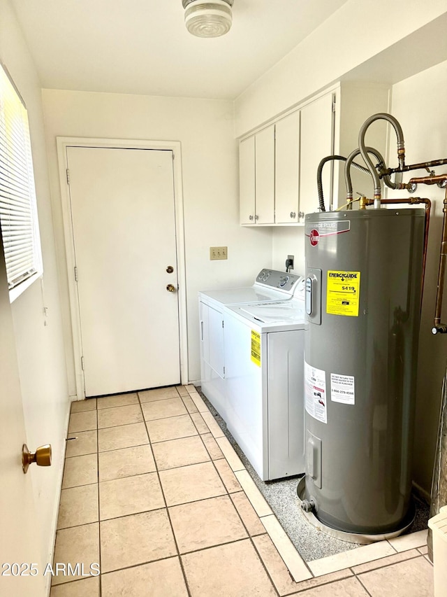 laundry area with electric water heater, washing machine and clothes dryer, cabinet space, and light tile patterned flooring