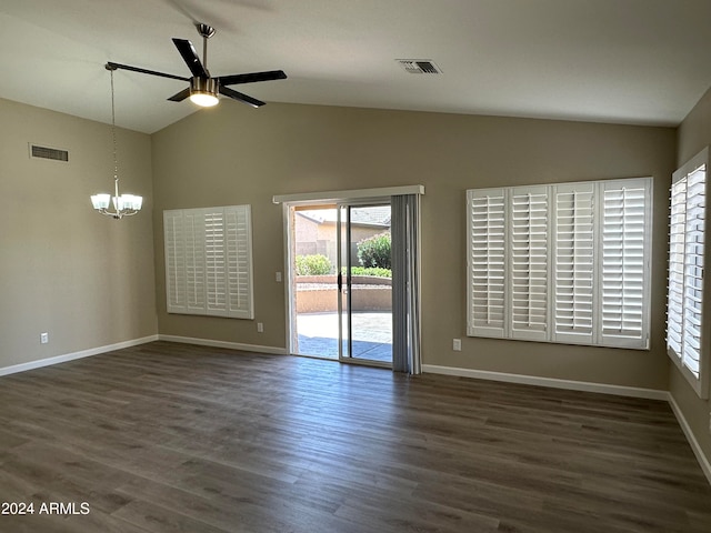 spare room with ceiling fan with notable chandelier, dark hardwood / wood-style flooring, and vaulted ceiling