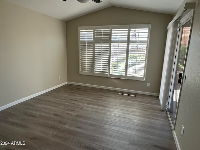 empty room with ceiling fan, dark hardwood / wood-style flooring, and lofted ceiling