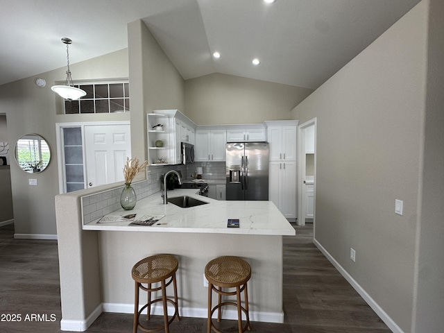15075 W Amelia Dr, Goodyear, AZ 85395 - kitchen with appliances with stainless steel finishes, open shelves, a peninsula, lofted ceiling, and decorative backsplash