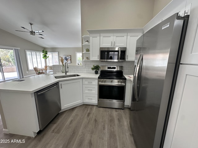 15075 W Amelia Dr, Goodyear, AZ 85395 - kitchen with stainless steel appliances, a peninsula, wood finished floors, a ceiling fan, and backsplash