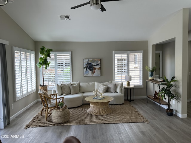 15075 W Amelia Dr, Goodyear, AZ 85395 - living area with vaulted ceiling, healthy amount of natural light, wood finished floors, and a ceiling fan