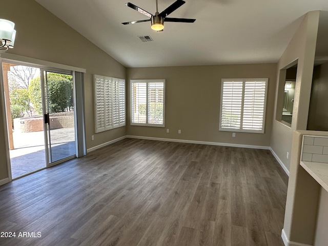 spare room featuring dark hardwood / wood-style floors, ceiling fan, a wealth of natural light, and vaulted ceiling