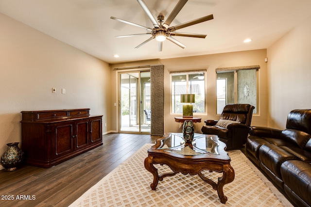 living room with ceiling fan and dark hardwood / wood-style flooring